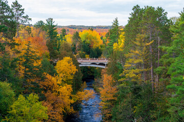 Bridge over a river in a colorful autumn woodland