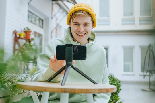 Young man blogger making vlog using smartphone outdoor