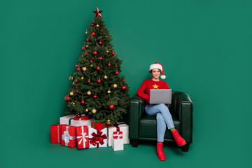 Full length portrait of attractive person sit chair use netbook eshopping isolated on green color background