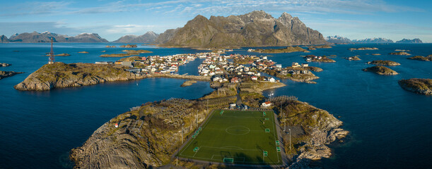 Incredible aerial view of Henningsvaer, football field and mountains in the background.
