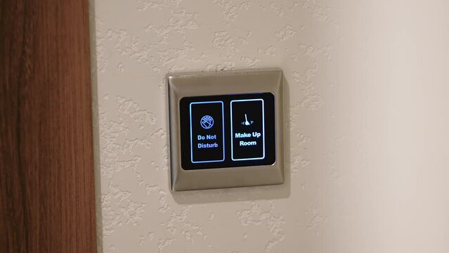 Close-up image of a person pushing a button on a display to clean a room. Electronic door sign in a modern hotel. Makeup in the room