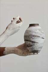 Closeup of black man holding handmade ceramic vase, art and artist concept - obrazy, fototapety, plakaty