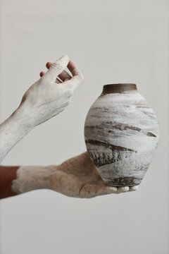 Closeup of black man holding handmade ceramic vase, art and artist concept