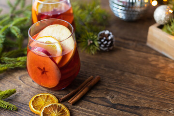 Glasses of hot mulled wine with fresh fruit apples and oranges. Traditional winter drink