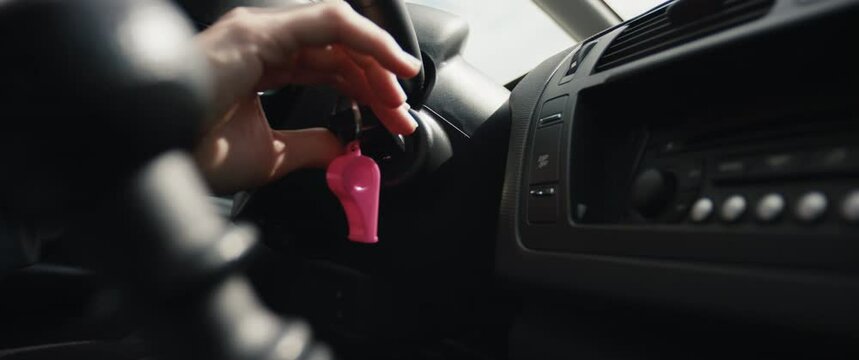 Woman driver hand key starts a car shift gears female drives close up