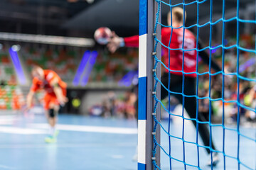 Detail of handball goal post with net and penalty shot in the background. - obrazy, fototapety, plakaty