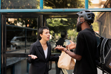 Office food delivery delay, courier giving wrong order to furious client, angry employee receiving lunch late. Deliveryman giving impulsive unsatisfied customer takeaway meal