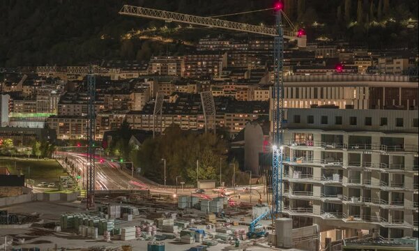 Contrucci&oacute;n en Andorra de edificio nocturna con gr&uacute;a en movimiento y coches de fondo