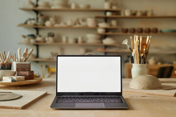 Background image of opened laptop with blank white screen in pottery workshop, copy space - Powered by Adobe