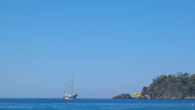 Luxury ships in blue bay under sun. A fantactic view of boating ship by the green hills in the blue water of ocean.