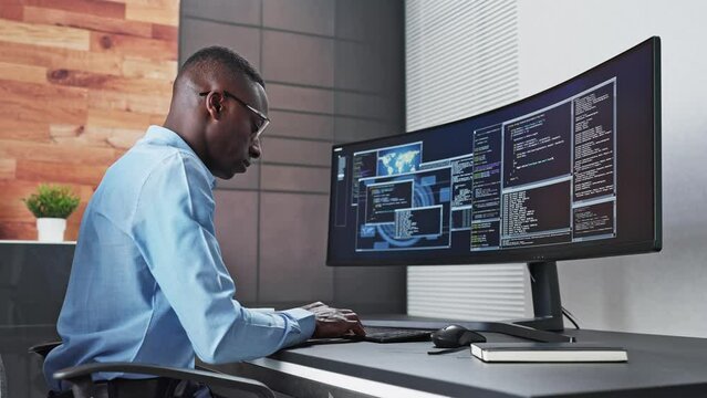 African American Coder Using Computer At Desk