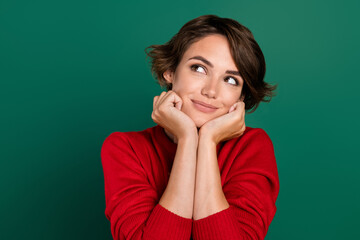Photo of nice brown hair young lady hands face look up wear red sweater isolated on green color...