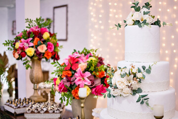 a 4-tier wedding cake, and flower arrangements on a table