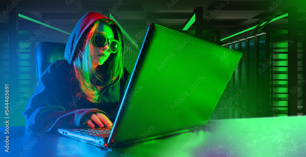Poster woman programmer. laptop on desk hacker girl. female in hooded sunglasses. programmer uses computer 