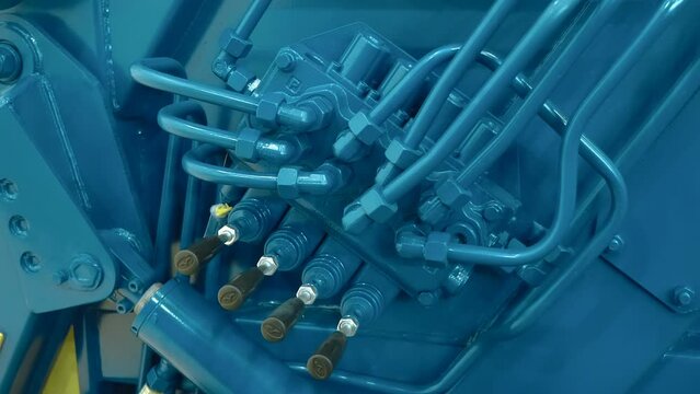 The block of hydraulic control valves of the new truck, which is responsible for the movement of the body, crane, winch, compaction of garbage. Shot in motion. Closeup