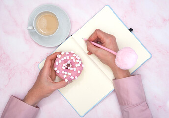  the girl calculates in a notebook the calories of a donut and a cup of coffee