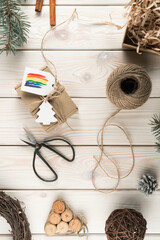 Vertical composition natural organic, fabric wrapped box with rainbow label, festive cards with scissors and rope sleave
