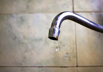 Old dirty faucet in the bathroom.Old water faucet.Drips from an old rusty faucet.