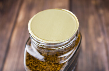 Glass jar with instant coffee on the table. Packaging with instant coffee close-up.