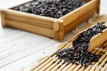 raw fresh black rice on wooden rustic background