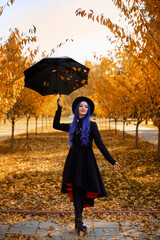 Girl with purple hair in autumn in the park