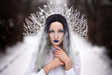 Cosplay snow queen in the forest in winter