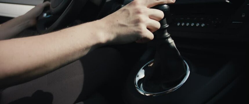 Female hand shifts gears gearshift lever drive car sunny day close up