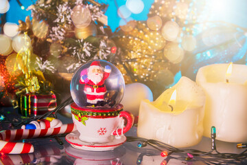 christmas background with christmas candles and a glass ball with santa claus