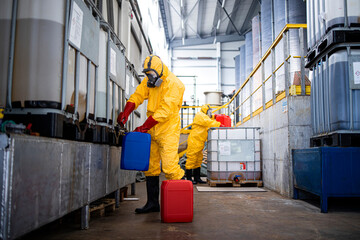 Providing acids and chemicals for galvanizing in metal factory. Workers in yellow protective suit...