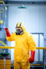 Chemical worker taking a shower and washing off aggressive chemicals after accident in acid...