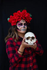 Woman skull makeup for mexican celebration day of the death with flowers black background