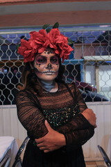 Woman skull makeup for mexican celebration day of the death with flowers black background