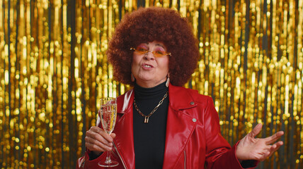 Funny woman in red jacket listening music, smiling dancing to disco party music, drinking champagne, having fun. Senior grandmother celebrating winning, birthday, xmas isolated on shiny background
