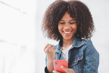 Excited african American millennial  female hold smartphone happy wining online, overjoyed black ...