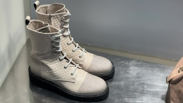 Women's white high-soled boots or lug sole boots with rhinestones stand in a shoe store window