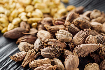 a barrel of dried black cardamom on a black wooden rustic background