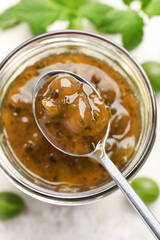 Jar of delicious gooseberry jam and fresh berries on white wooden table, flat lay