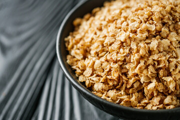 fresh raw buckwheat flakes on a black wooden background