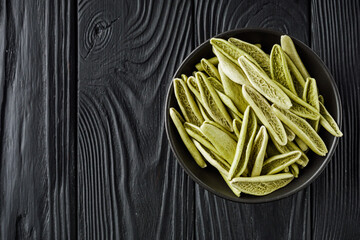 raw green cavatelli pasta on a black wooden background