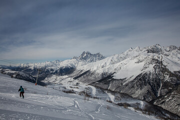 Fototapeta na wymiar Snowboarding freeride at the ski resort on the background Mount Ushba covered with snow and glaciers, Caucasus Mountains, Georgia
