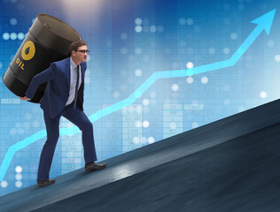 Businessman under the burden of oil barrel