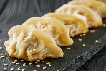 delicious fried gyoza dumplings on a black plate