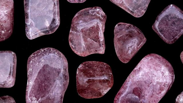 Strawberry quartz rare jewel stones texture on black background. Moving right seamless loop backdrop.