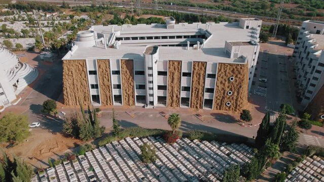 Modern cemetery with one-story burial building - Vertical Cemetery Aerial footage pull out shot  #001