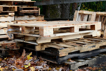A low angle image of serval broken wooden pallets stacked and waiting for recycling. 