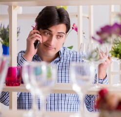 Man shopping in shop and calling his wife