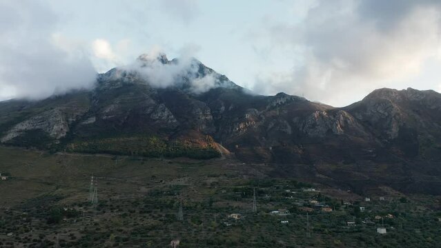 Rocky Peak Of Monte San Calogero Shrouded By Clouds In Palermo, Sicily, Italy. - aerial descend