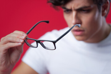 Checking his glasses, shortsighted man examining his spectacles, blurred person behind the glasses,...