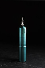 Tattoo machine on slate table against black background