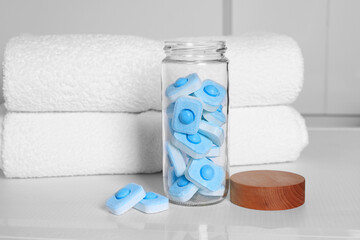 Glass jar with water softener tablets on washing machine in bathroom - obrazy, fototapety, plakaty